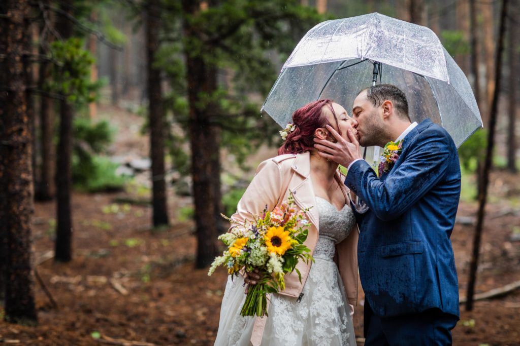 Groom pulling the bride in for a kiss in the rain at their Dao House Wedding