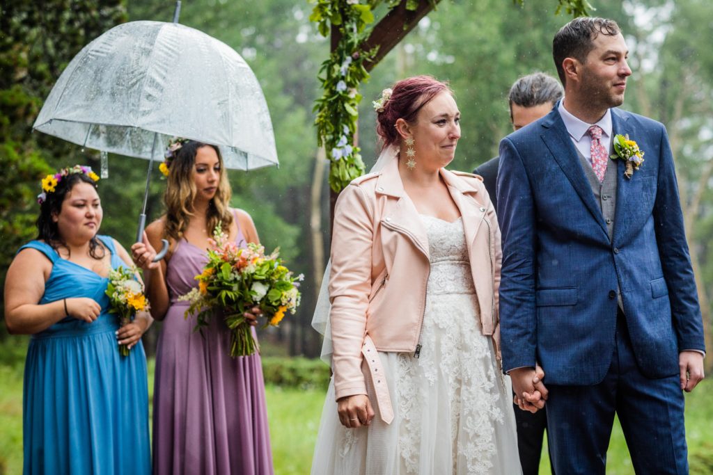 Bride and groom crying in the rain while listening to a poem