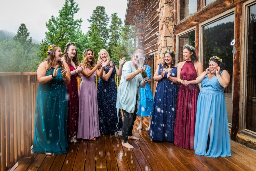 Bride popping champagne with her bridesmaids at the Dao House in Estes Park