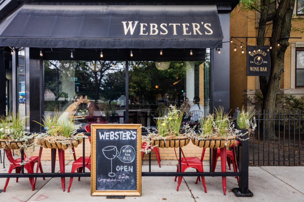 Couple kissing in front of Webster's Wine bar