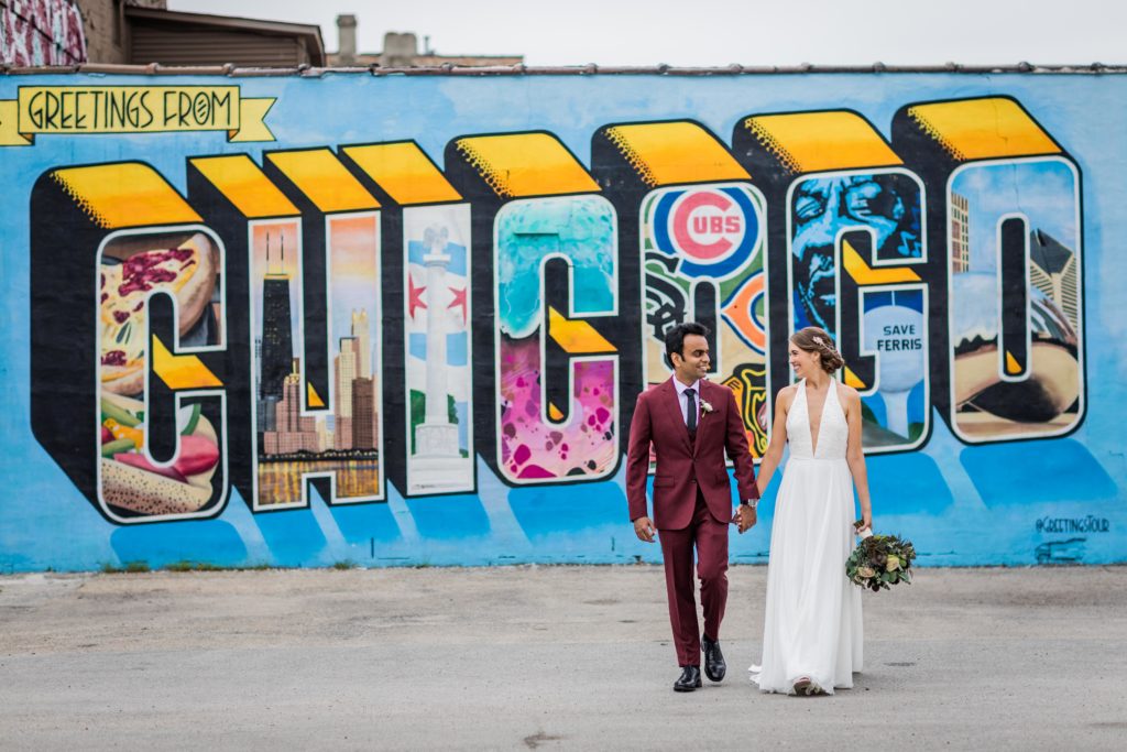 Couple walking in front of a mural in chicago before their Revolution Brewing Wedding