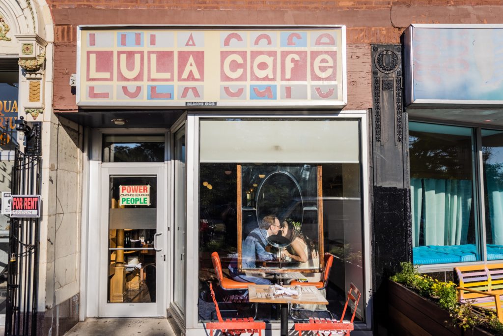 Couple kissing in the window at Lula Cafe