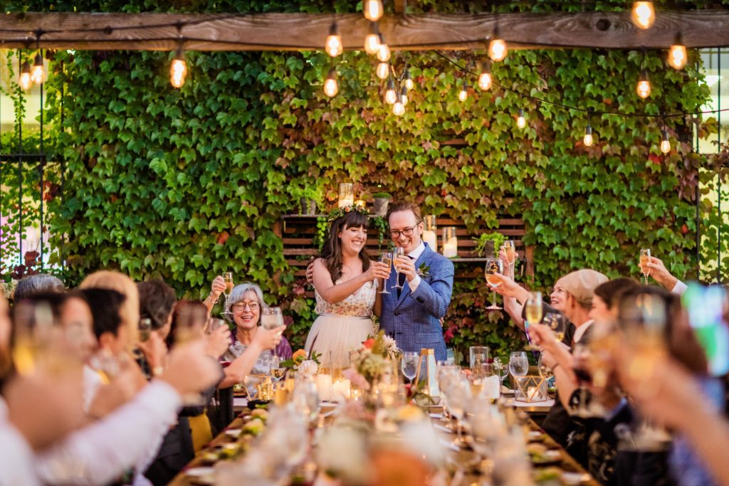 Couple clinking glasses for a toast during their Big Delicious Planet Wedding