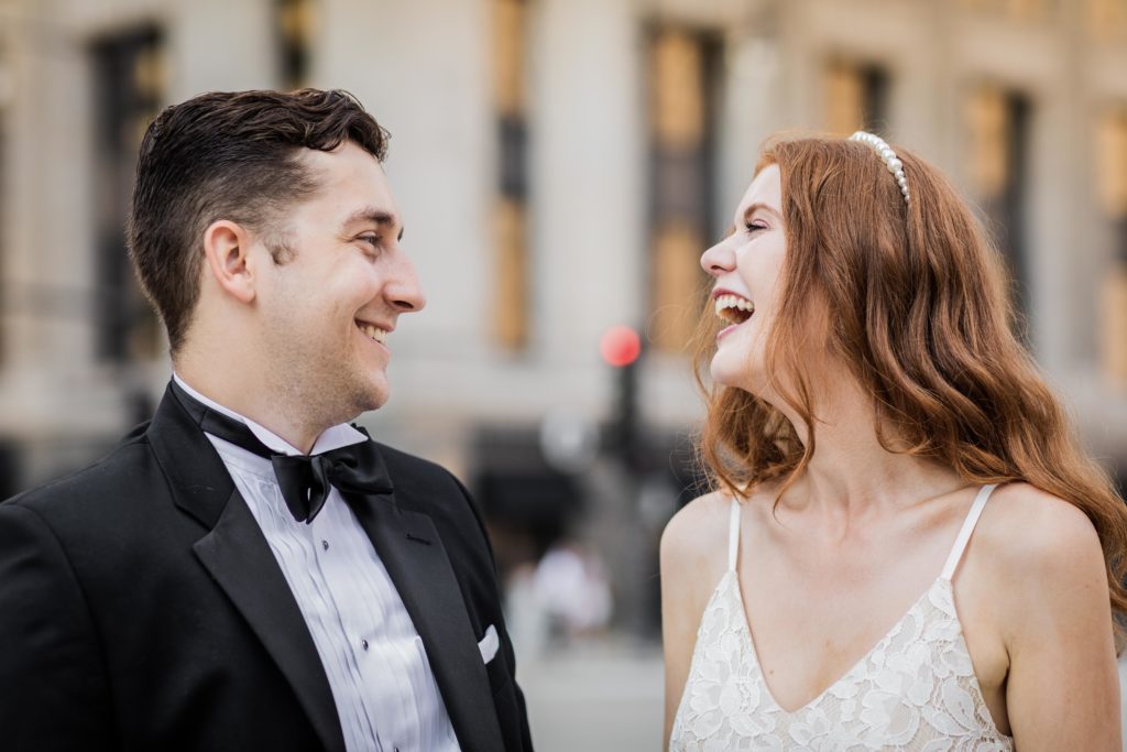Bride and groom looking at each other and laughing after their Chicago City Hall wedding 
