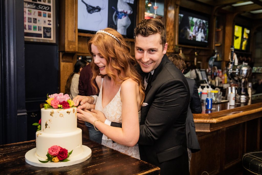 Bride and groom cutting the cake during their Kirkwood bar reception