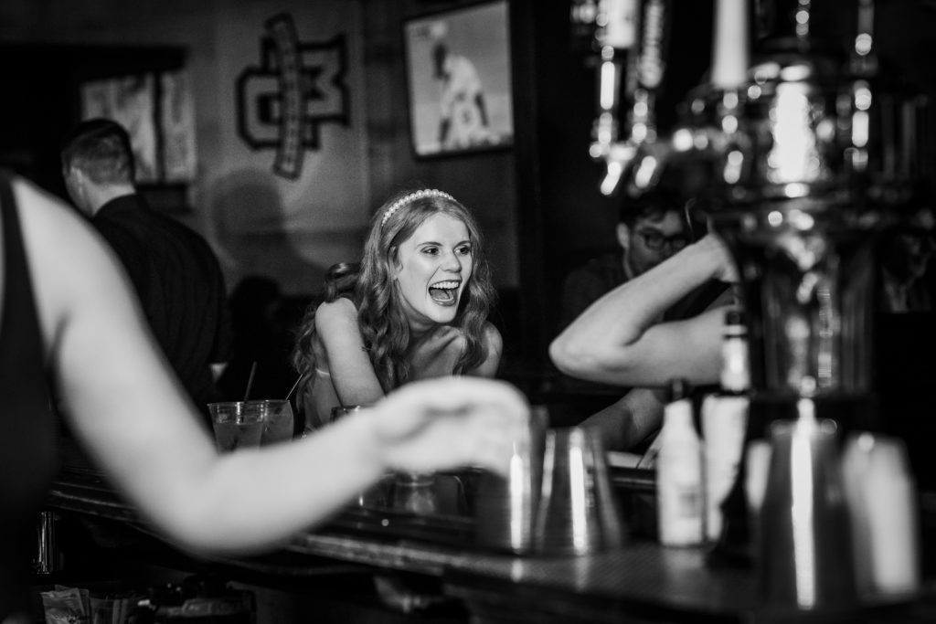 Bride laughing at the bar