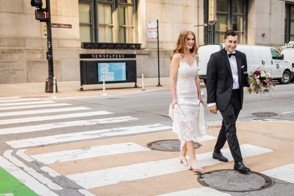 Bride and groom crossing the street after their Chicago City Hall wedding 