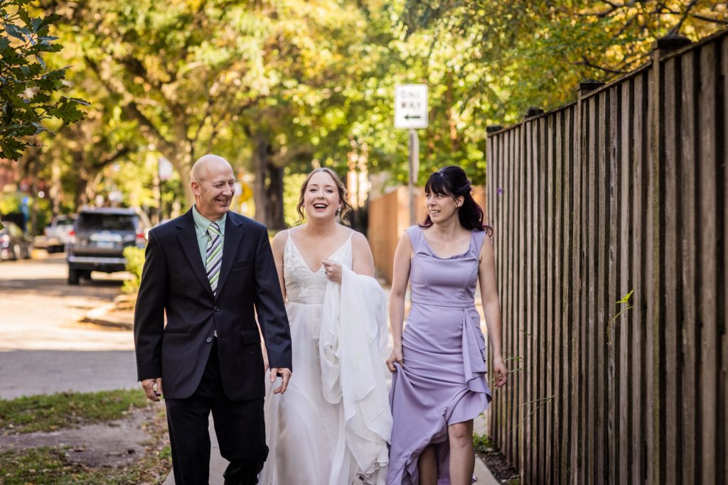 Bride walking with her sister and her father