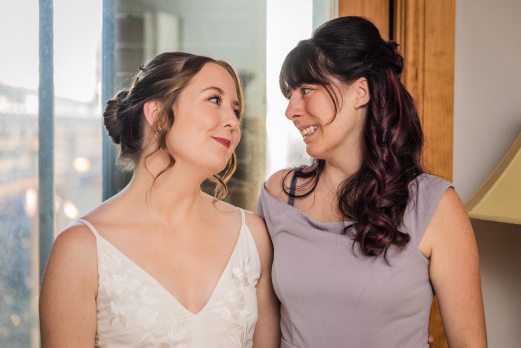 Bride and sister looking at each other before her Lincoln Park Conservatory Wedding