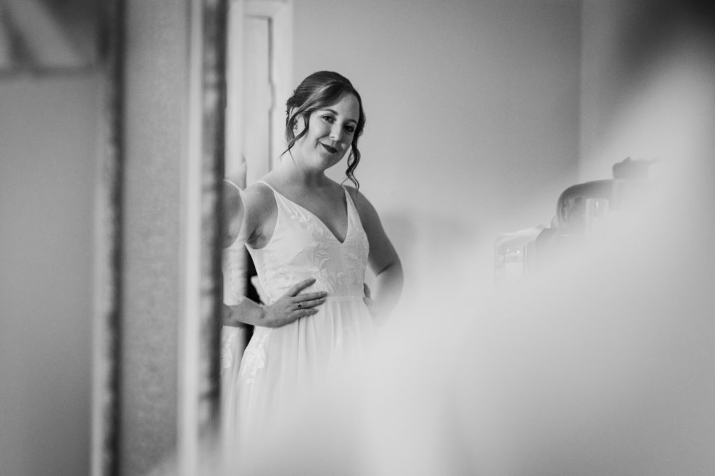 Bride smiling at herself in the mirror