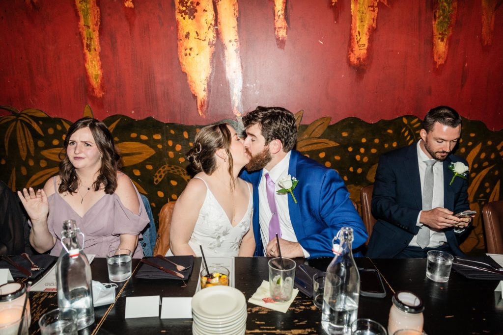 Bride and groom kissing at their reception