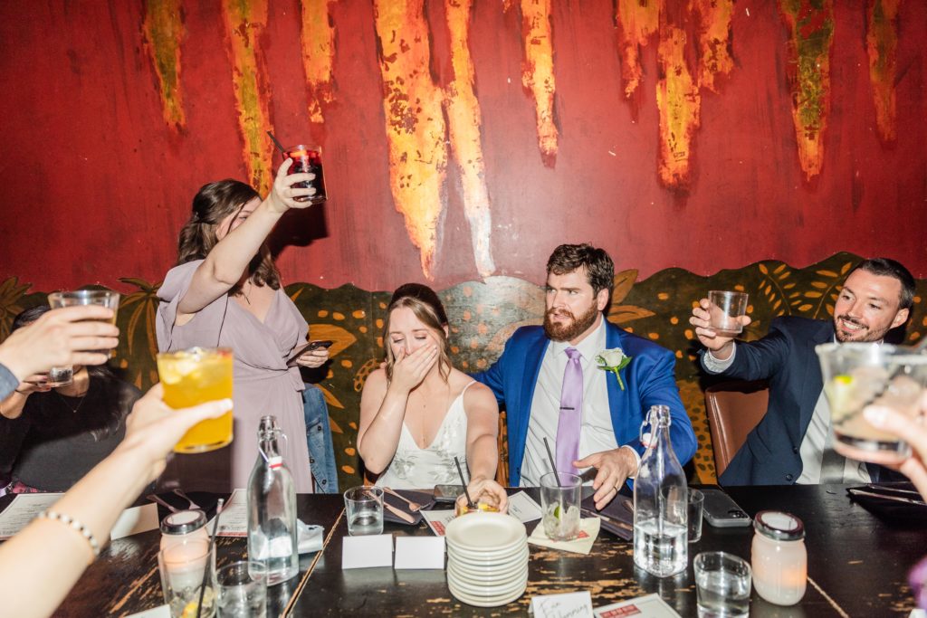 maid of honor holding up a glass and toasting the bride and groom