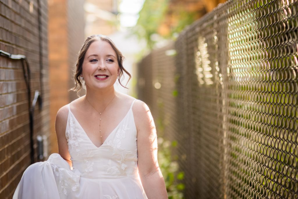 Bride smiling in an alleyway