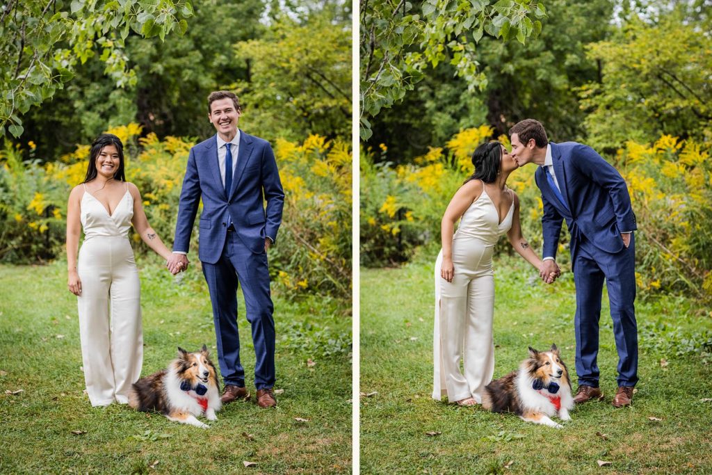 Couple kissing while holding hands and standing over their dog in a bowtie