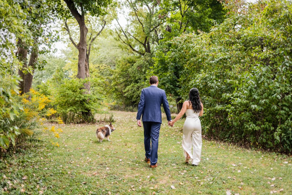 Bride and groom walking with their dog and holding hands after their elopement in Chicago