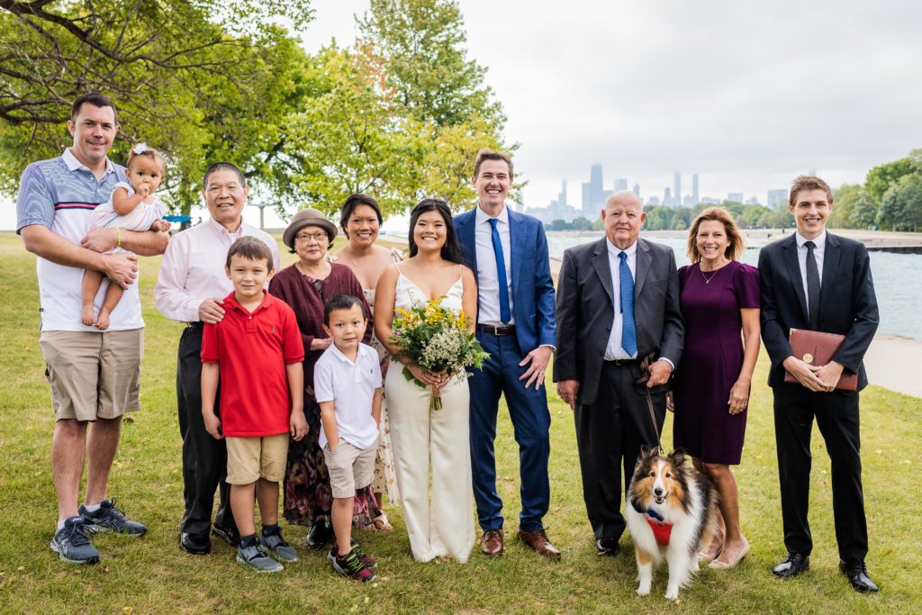 Bride and groom posing for a photo with their families