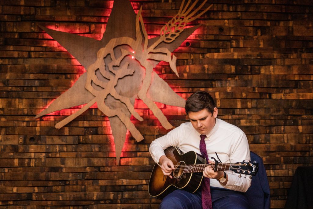 Man plays the guitar on stage at Revolution Brewing