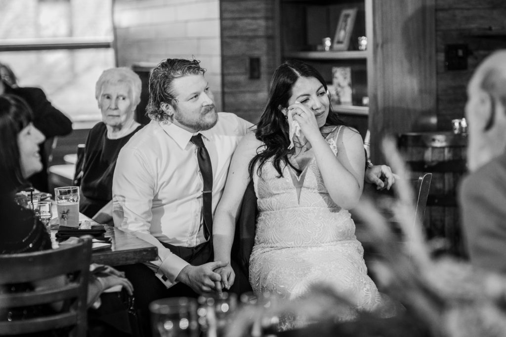 Bride wipes tears away while listening to a speech at her Revolution Brewing Wedding