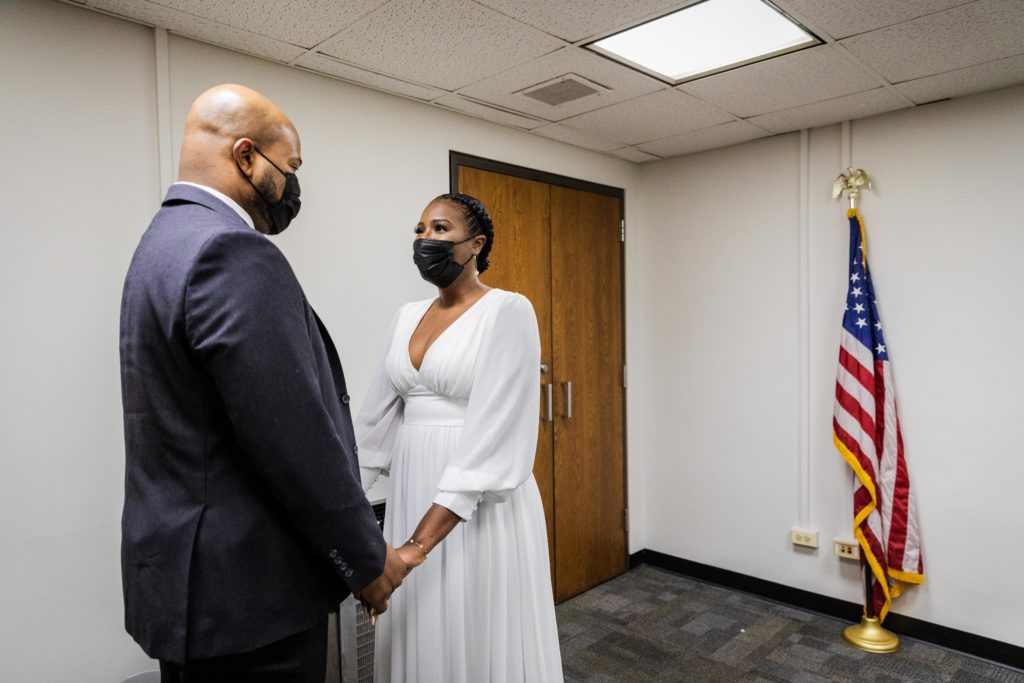 Bride and groom look at each other during their Chicago city hall wedding ceremony