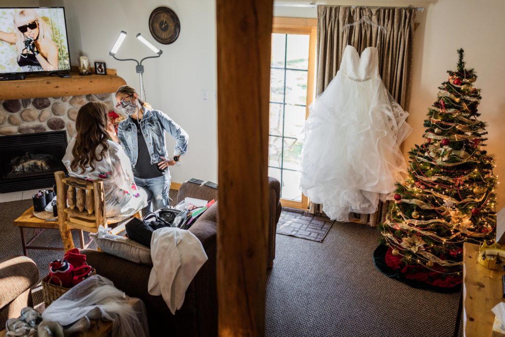 Bride getting ready with the dress hanging next to a Christmas tree