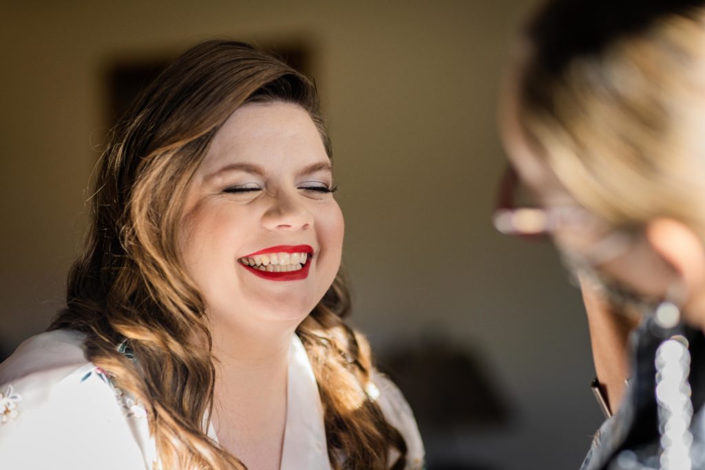 Bride laughing as she gets her makeup done before her wedding at  Starved Rock