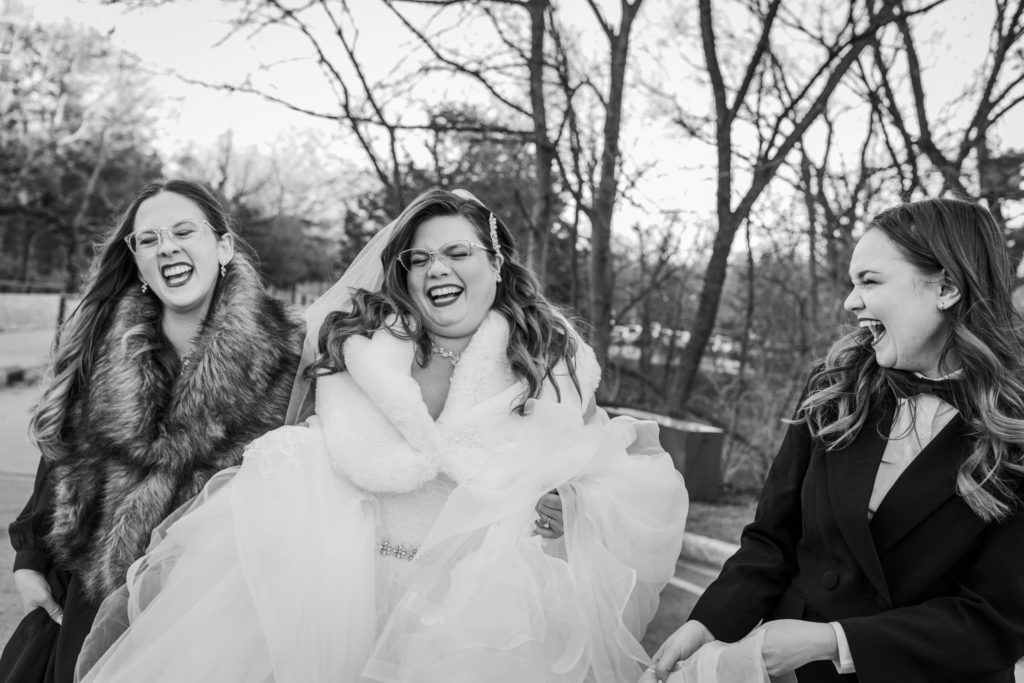 Bride laughs with her maid of honor and her step daughter