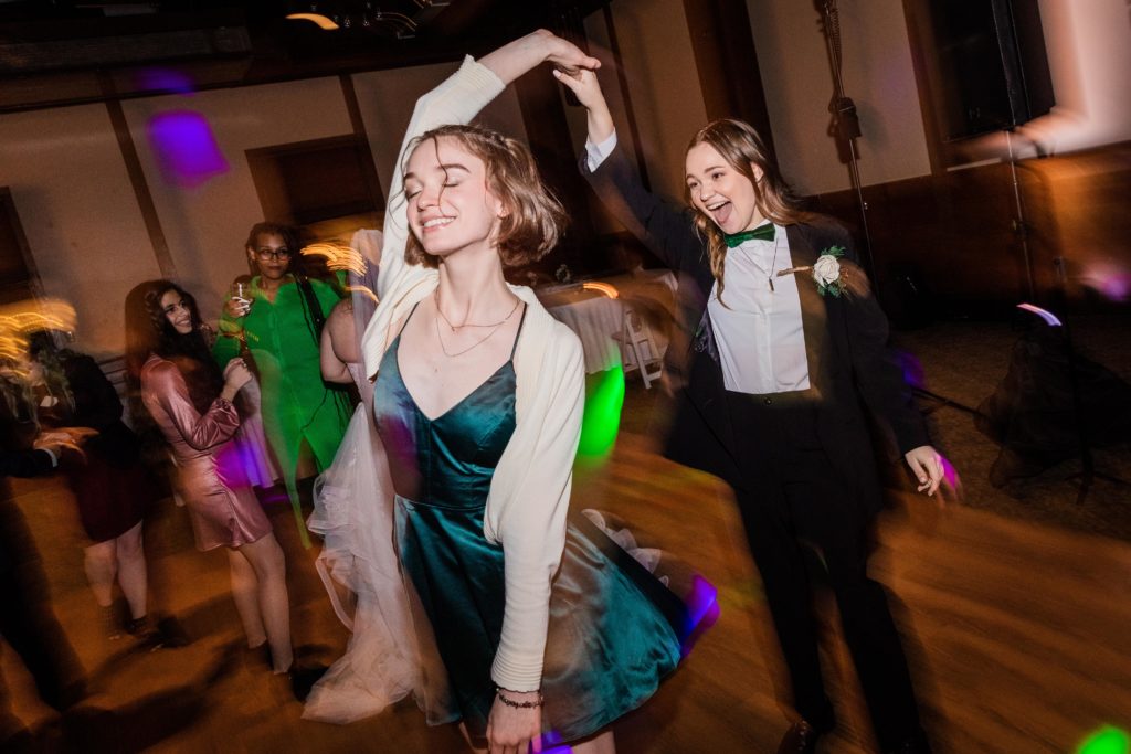 Daughter of the groom twirls friend on the dance floor
