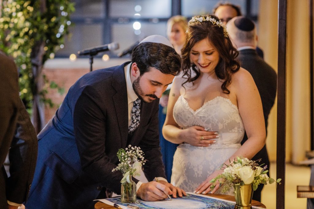 Bride and groom sign the Ketubah at Ovation Chicago