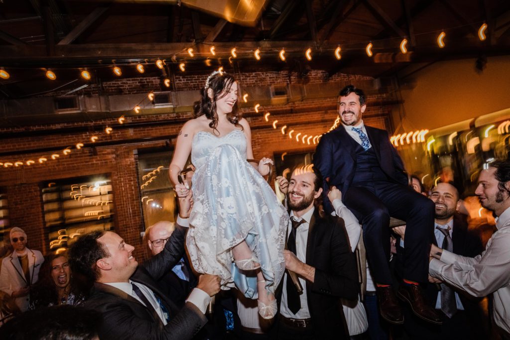 Couple laugh during the hora during their wedding at Ovation Chicago