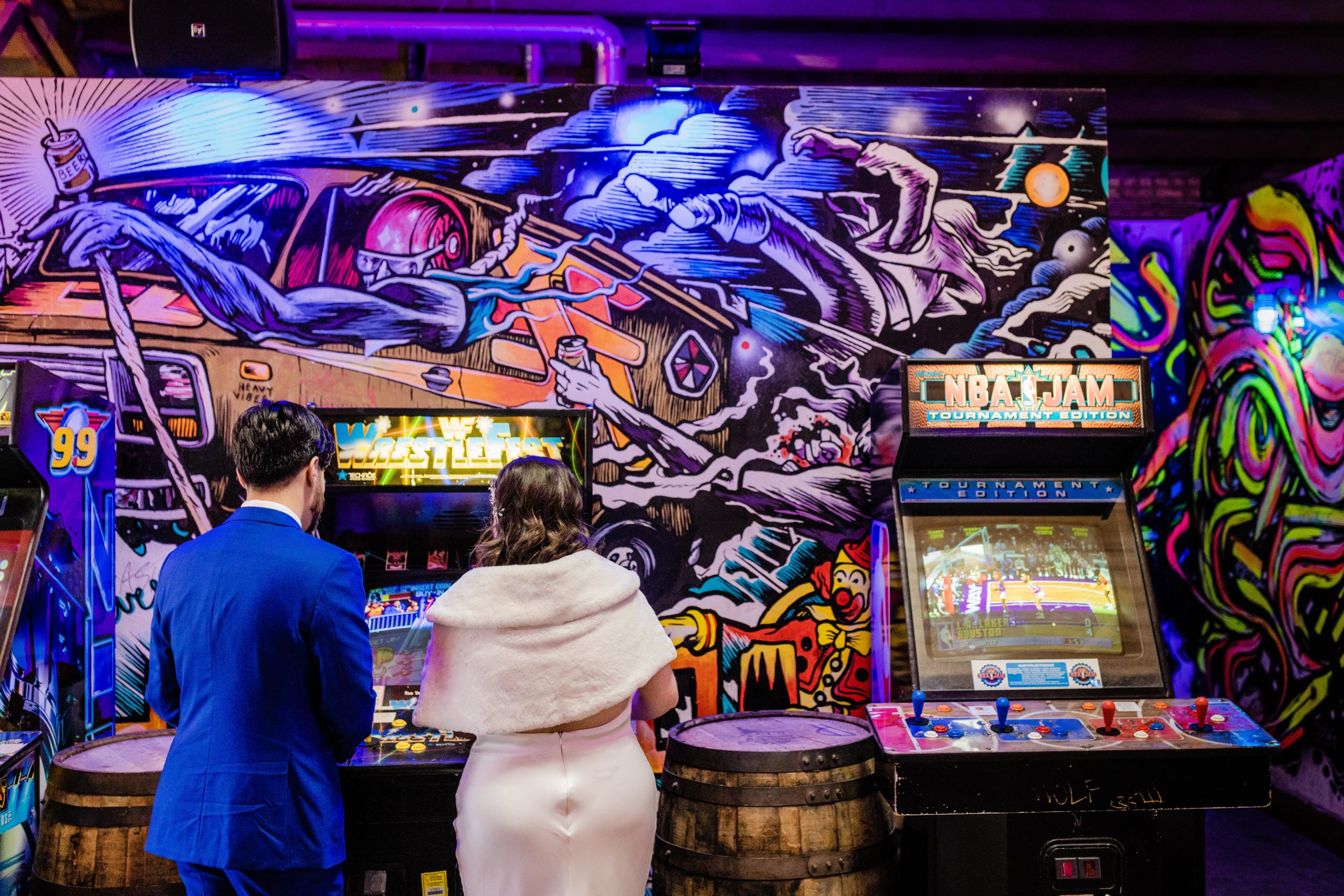 Bride and groom playing video games at Emporium Arcade Bar