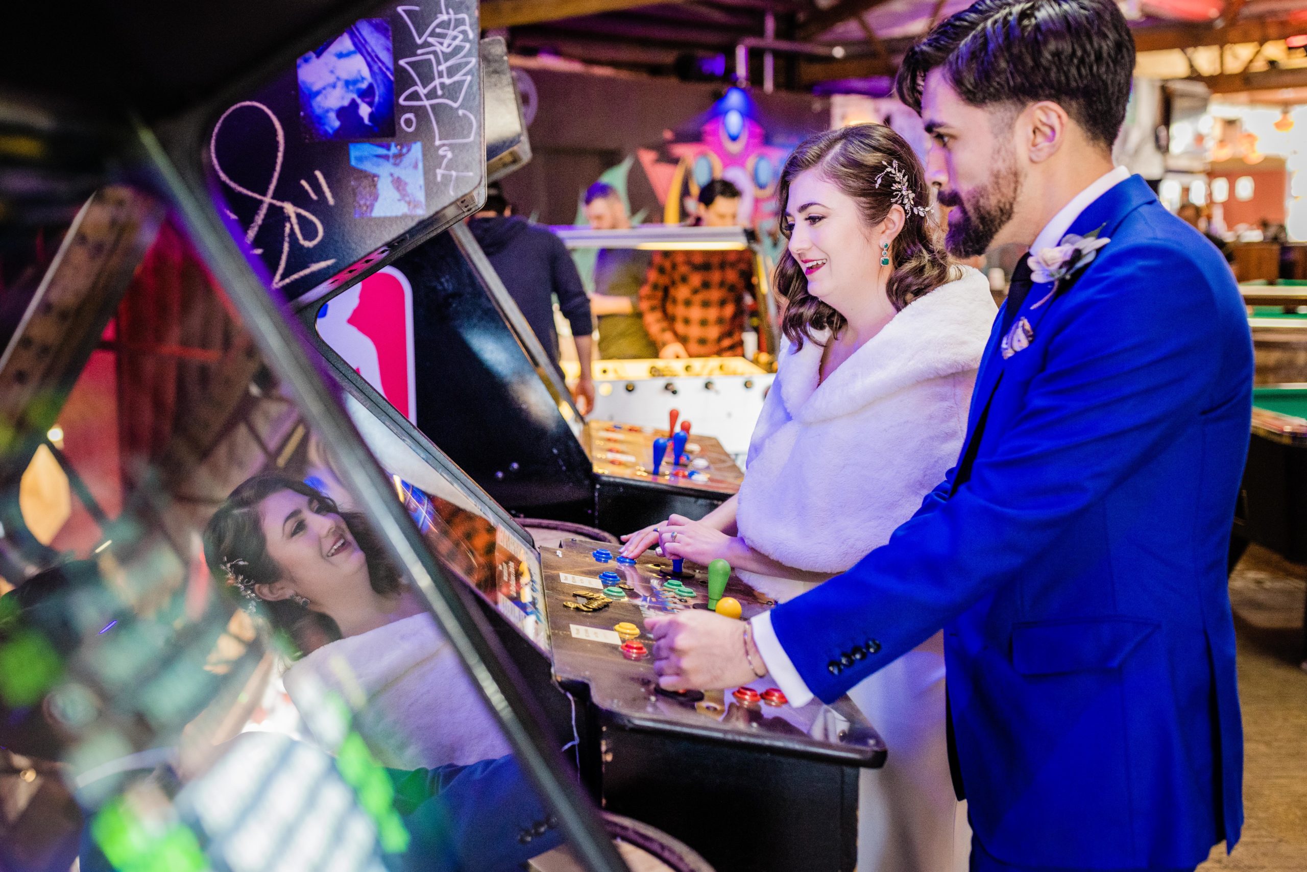 Bride and groom laughing at Emporium Arcade Bar in Logan Square