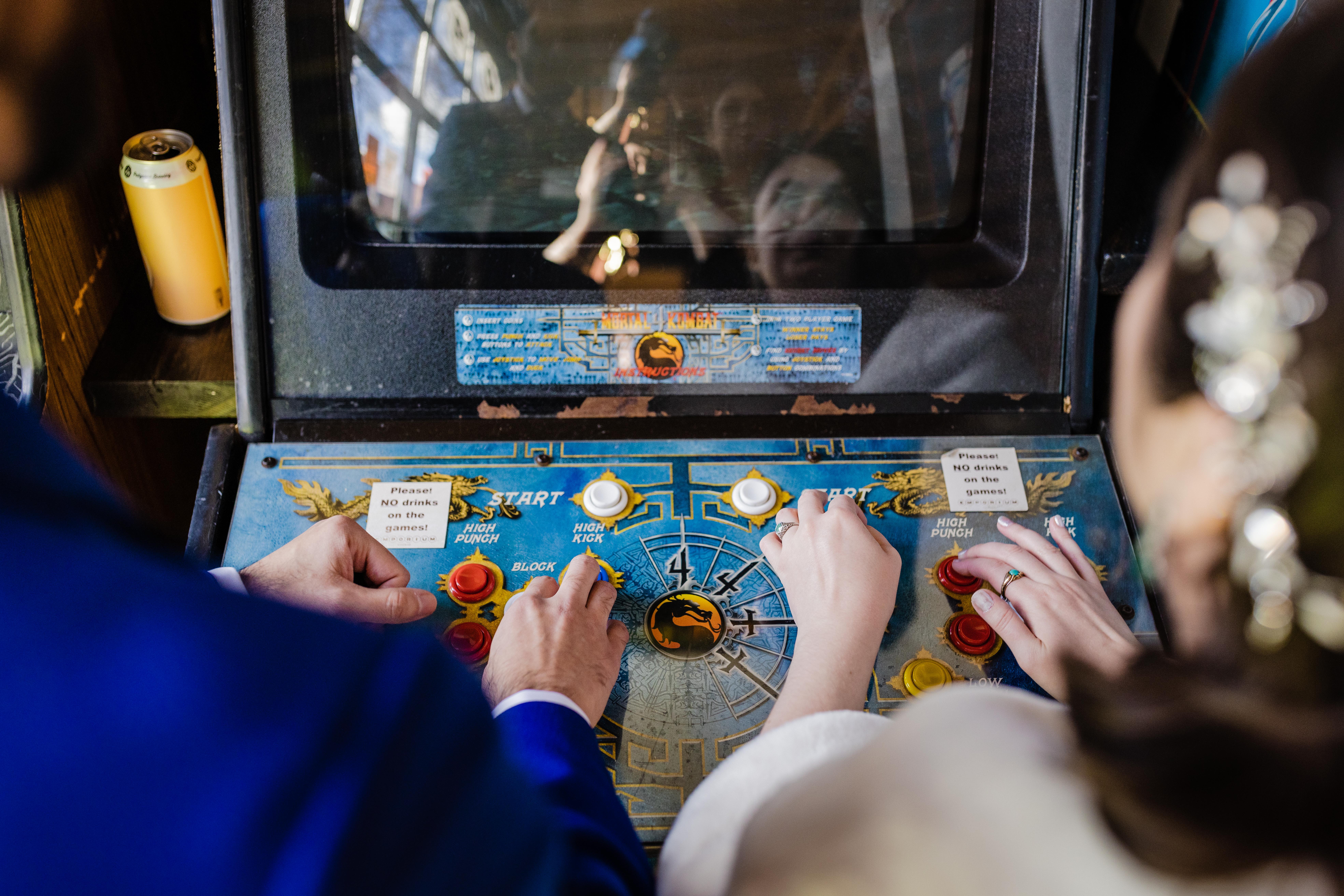 Bride and groom's hands playing arcade games before their Revolution Brewing Wedding