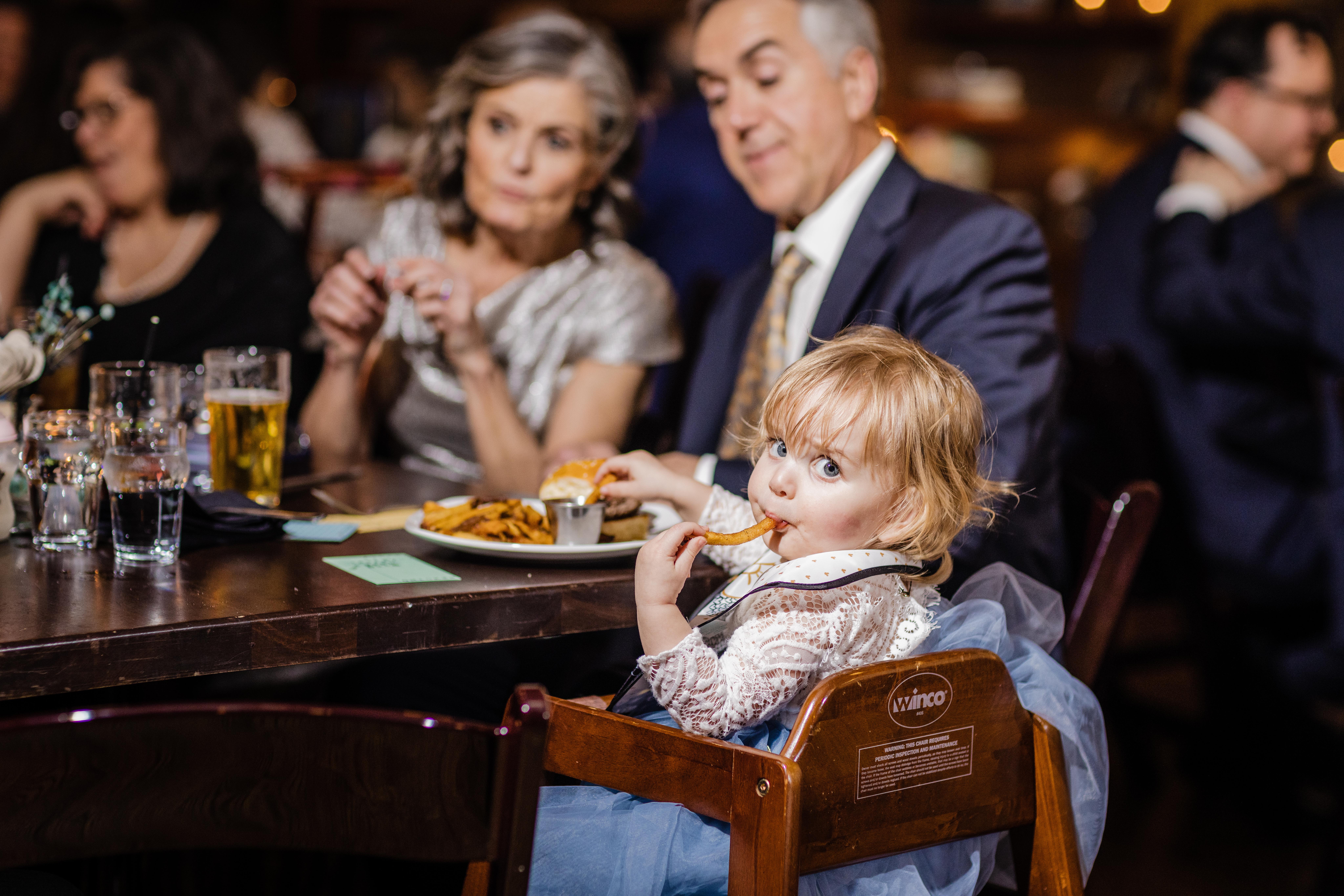 Little girl eating a french fry at a Revolution Brewing Wedding