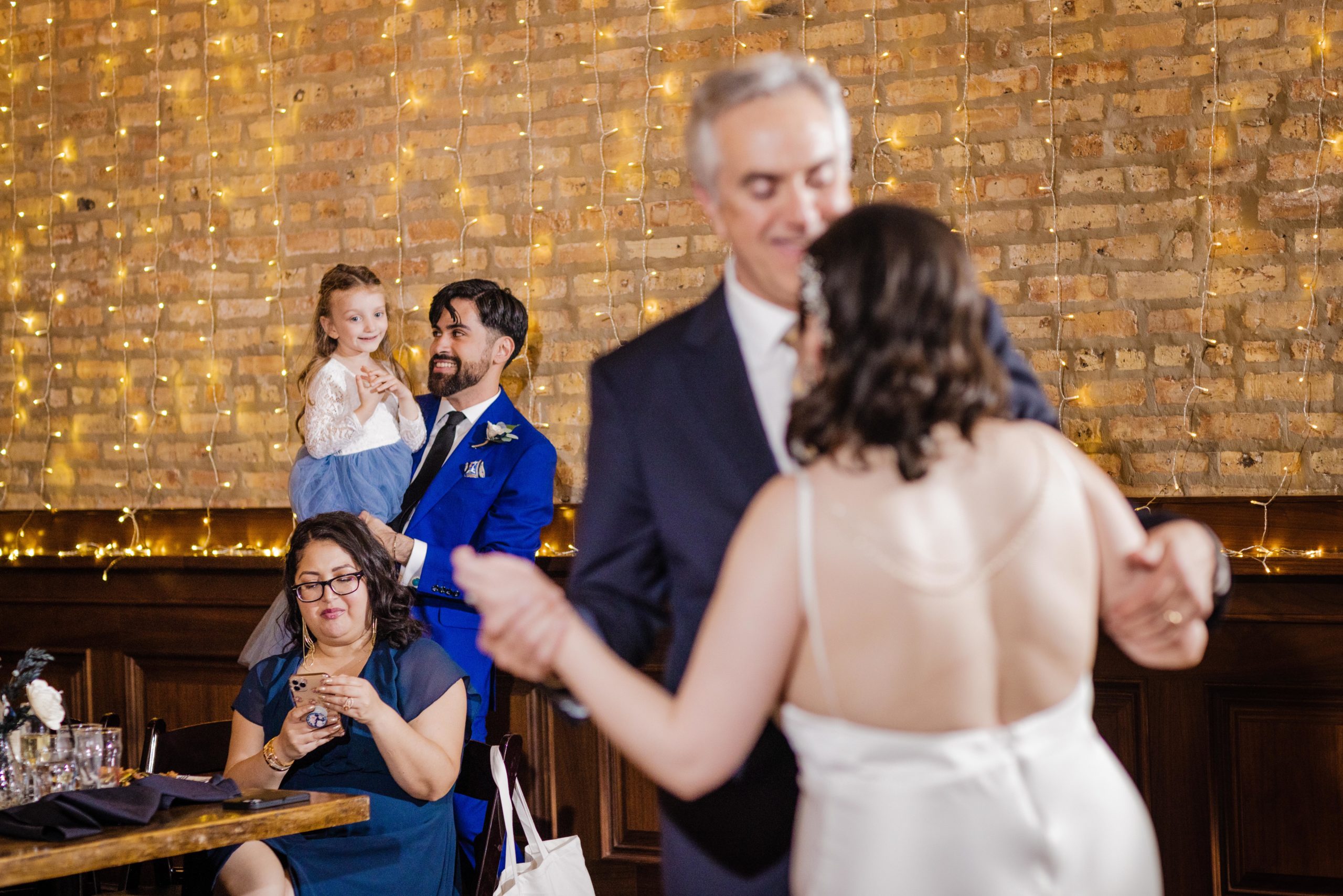 Groom and niece watch the bride dance with her father at their Revolution Brewing Wedding