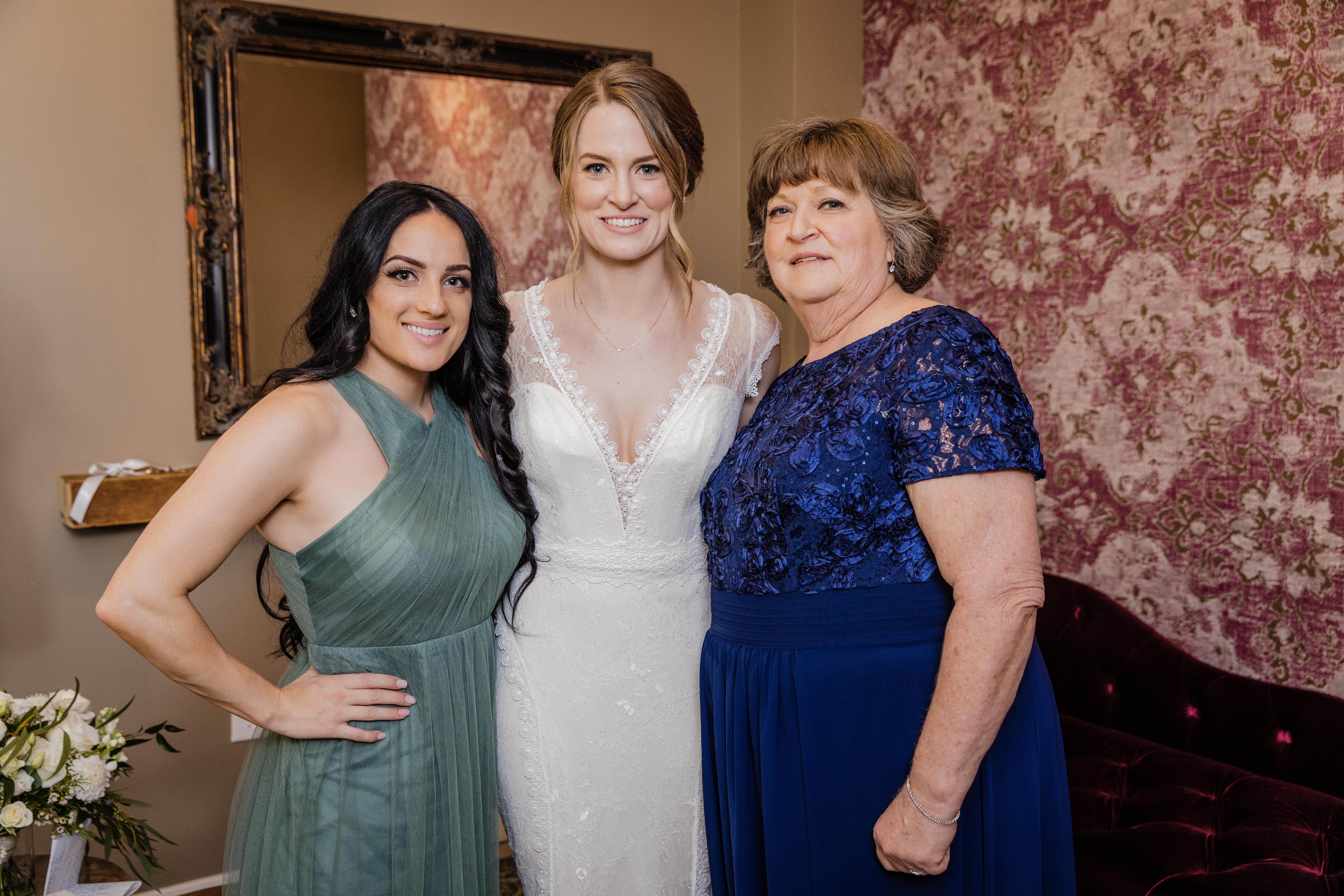Bride posing with her maid of honor and her mom