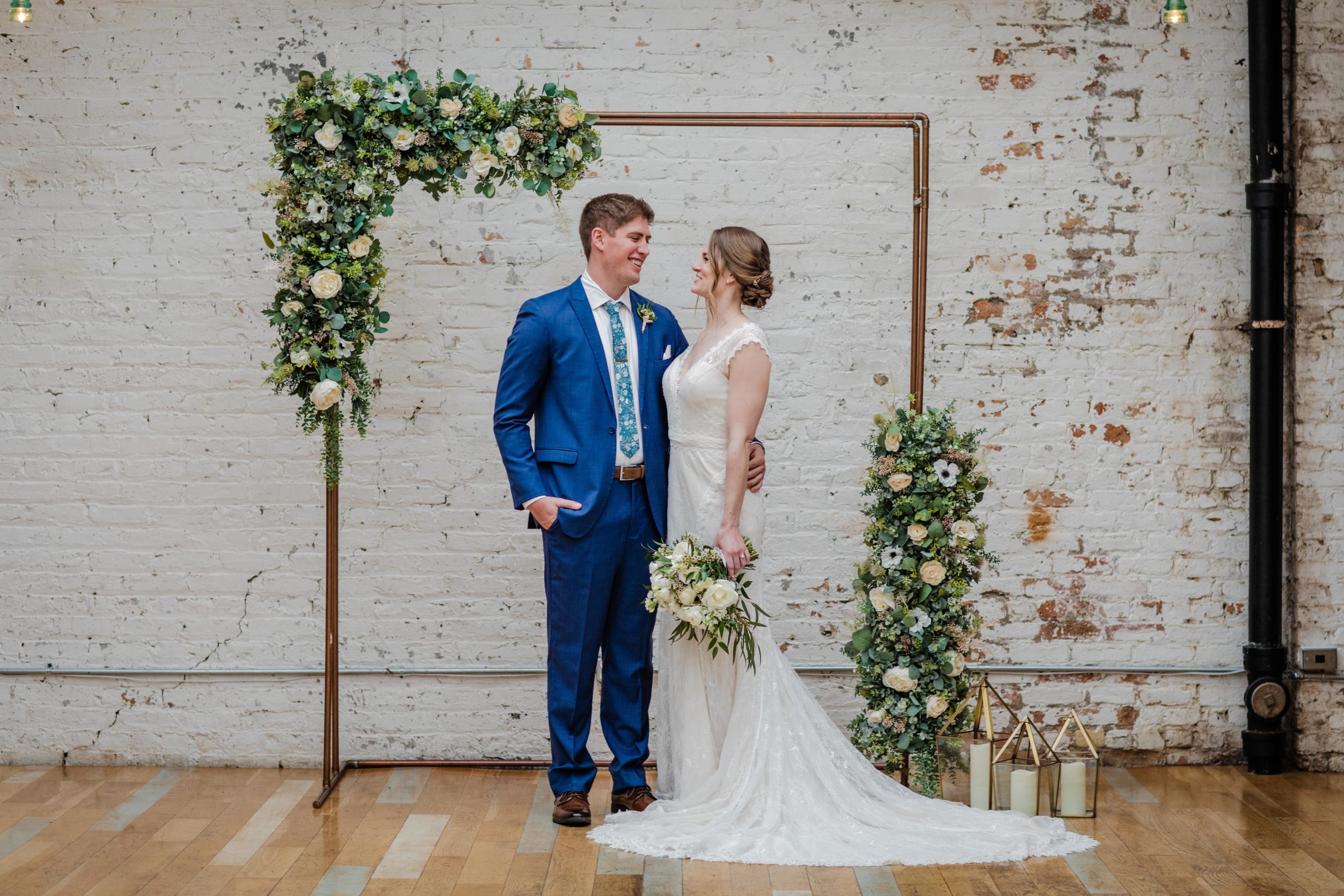 Couple posing under wedding arch at The Joinery