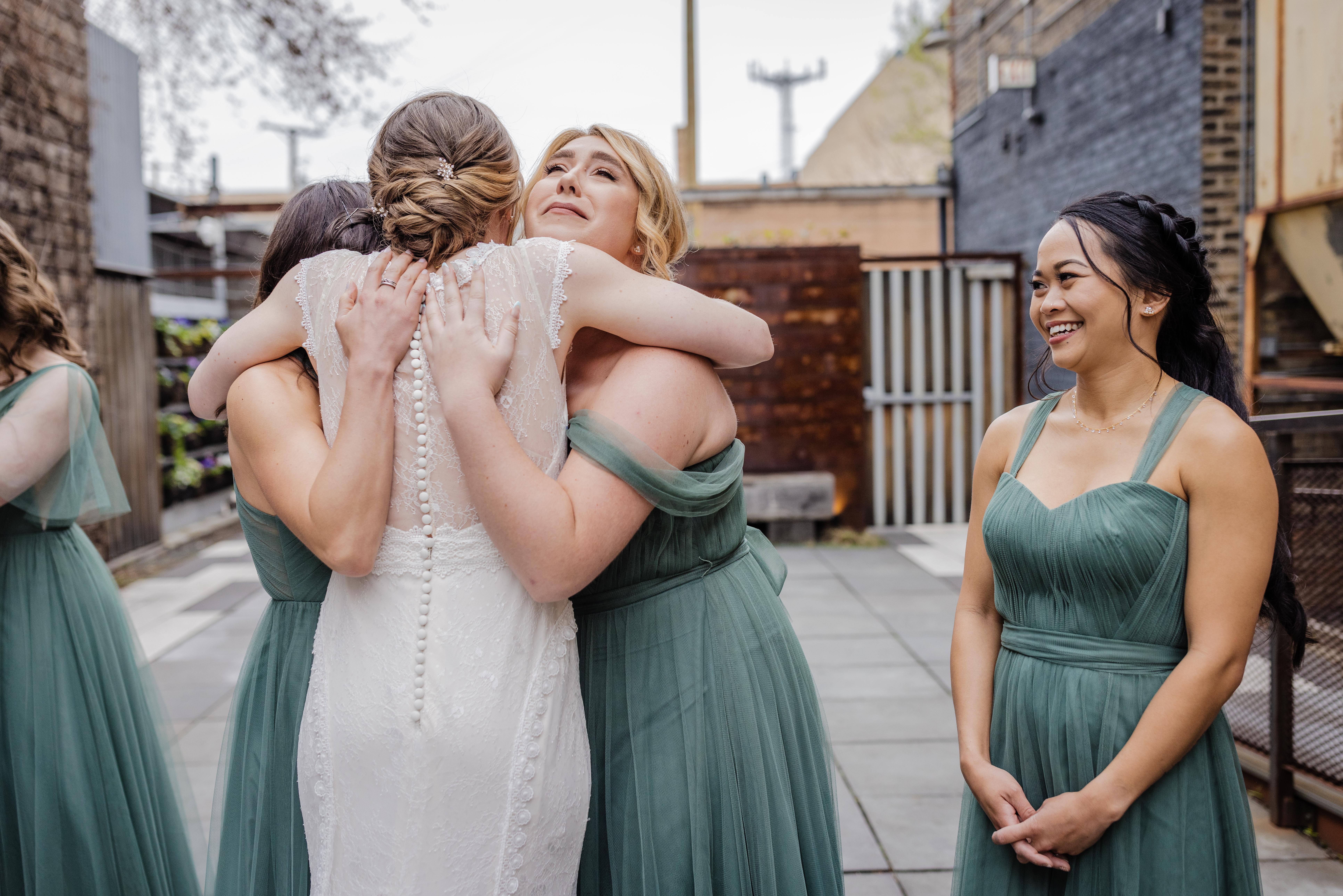 bridesmaids hugging the bride