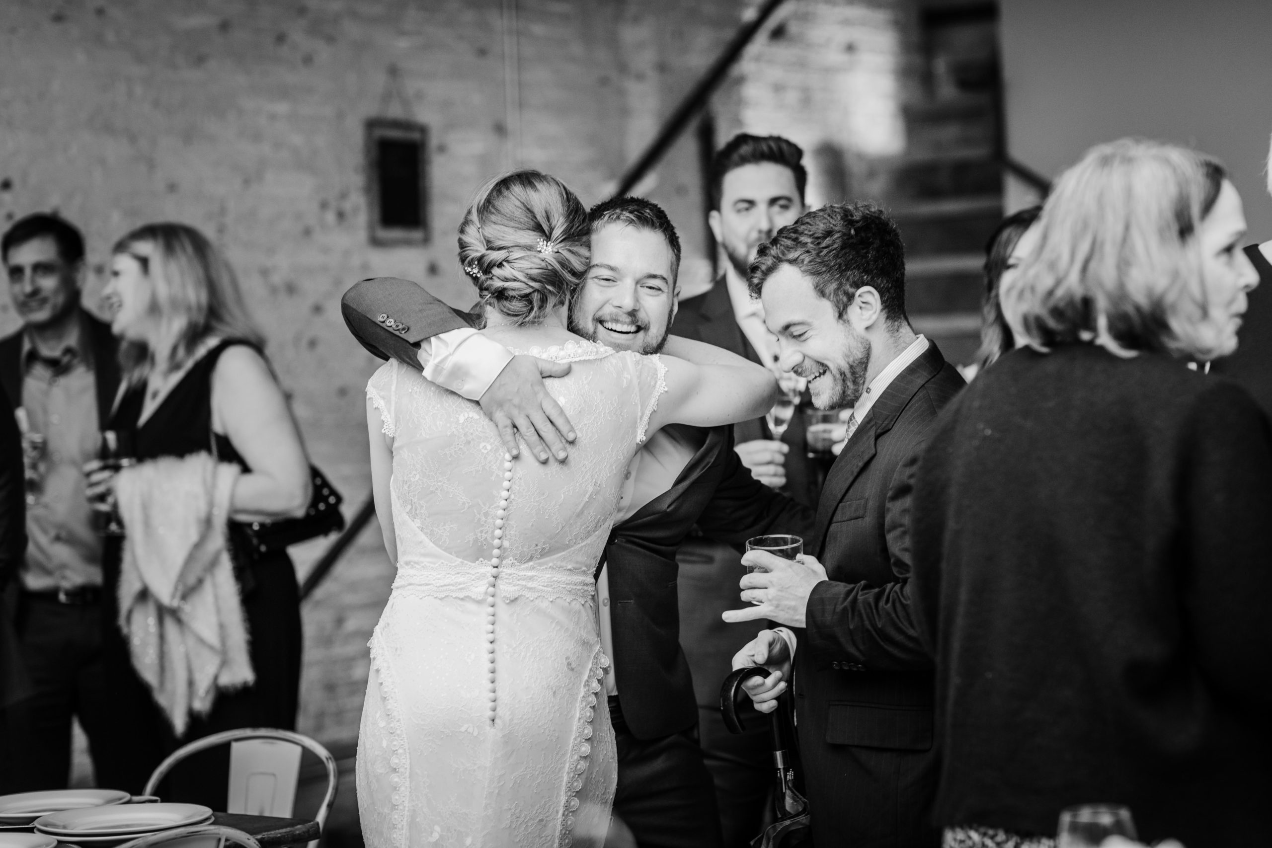 Bride hugging friend during cocktail hour at the joinery